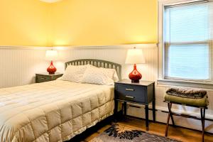 WiscassetGarden Hideaway的一间卧室配有一张床、两盏灯和一个窗户。