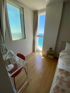 荷兹利亚spacious real two bedrooms at the daniel hotel的一间卧室设有一张床、一张玻璃桌和一扇窗户