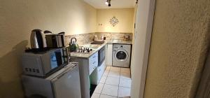 开普敦Walters Lane Economy Apartment 1 - No Loadshedding的厨房配有炉灶和洗衣机。