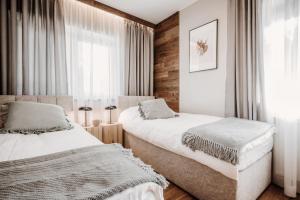 扎科帕内Apartament pod Nosalem的一间卧室设有两张床和窗户。