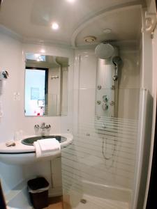 塞纳河畔罗米伊L'Hôtel du Marais Romilly Centre的白色的浴室设有水槽和淋浴。