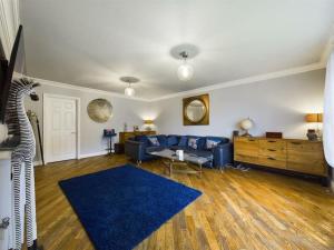 斯旺西-- Huge -- 5-bedroom home & Private Gym by Tailored Accommodation的客厅配有蓝色的沙发和蓝色的地毯。