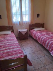 凯法利尼亚岛Kali’s comfort的客房设有两张床、一张桌子和窗户。