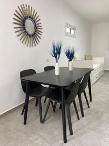 尼夫佐哈Romi's suite by LOREN VILLAGE的黑色餐桌,配有黑色椅子和镜子