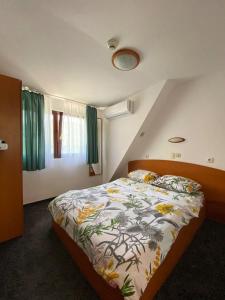 比卡兹Hotel Pescarus Port Bicaz的一间卧室配有一张带花卉棉被的床