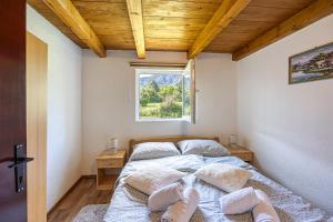 科雷尼察Holiday home Veki***的卧室配有带枕头的床铺和窗户。