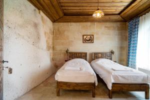 内夫谢希尔Cappadocia inans Cave & Swimming Pool Hot的配有两张单人床的木天花板客房