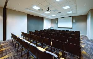 约翰内斯堡Garden Court Milpark的一间空的讲座室,配有椅子和屏幕