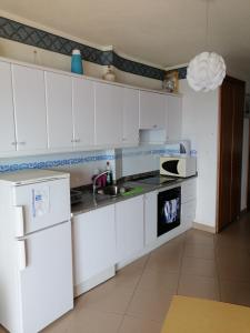 洛斯克里斯蒂亚诺斯Apartamentos Vista Bahia的白色的厨房配有水槽和微波炉