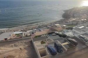 蓬塔赫尔莫萨Loft acogedor con área de parrilla y piscina的享有海滩空中景色,设有停车场