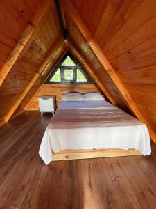 PazarMutlu apart ve bungalovs的木制客房的一张床位,设有窗户