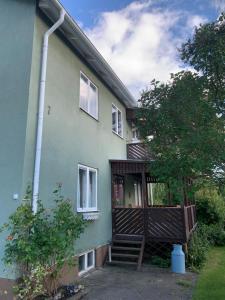 延雪平Lägenhet på Strömsholm的绿色房子的一侧设有木制阳台