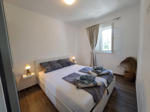 拉斯托伏Apartman Portorus的卧室配有白色的床和两个枕头