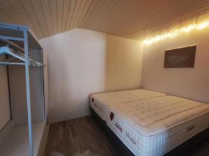 弗里堡Cosy appartement 1 chambre au coeur du bourg的小房间的小床,有架子