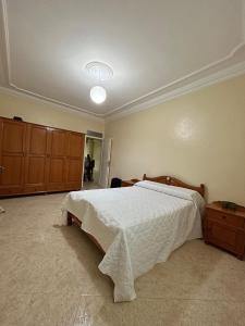 胡塞马Sfiha/Hoceima huis的卧室配有带白色棉被的床