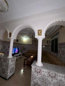 胡塞马Sfiha/Hoceima huis的客厅设有柱子、沙发和电视。