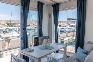 曼弗雷多尼亚Marina del Gargano Houseboat的客厅配有桌子,享有码头的景色