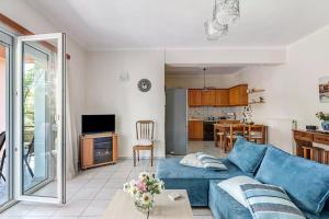 利吉亚House of Dreams Lefkada的一间带蓝色沙发的客厅和一间厨房