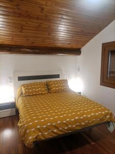 索特APARTAMENT BETTY的卧室内的一张床铺,设有木制天花板