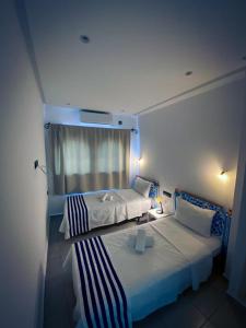 舍夫沙万Hotel Marrakech的酒店客房设有两张床和窗户。