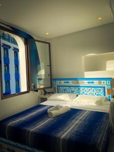 舍夫沙万Hotel Marrakech的卧室配有一张带镜子的蓝色和白色床