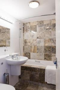 曼海德海滩酒店的一间带水槽、浴缸和卫生间的浴室