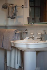 圣安德鲁斯Balmungo Cottage B&B的浴室配有盥洗盆、镜子和毛巾