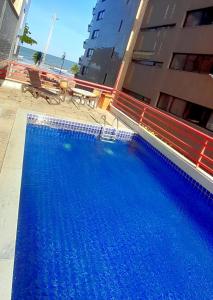 累西腓纳韦甘蒂斯累西腓美居酒店的一座大型蓝色游泳池,位于大楼旁边