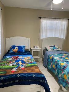 奥兰多Sunny days vacation rental LLC的一间卧室配有两张单人床和Hello套床单。