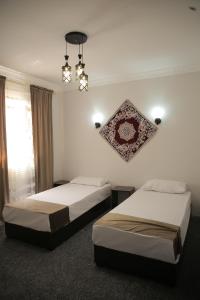 希瓦Rasul-Nazar的配有吊灯的酒店客房内的两张床