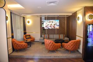 普罗夫迪夫普罗夫迪夫公园酒店的一间配备有橙色椅子和电视的等候室