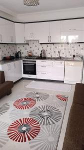 费特希耶2 Yatak Odalı Daire-Fethiye的厨房配有白色橱柜和地板上的地毯