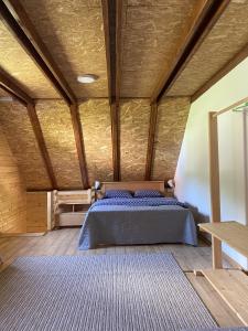 莫克拉戈拉Apartmani Milekić的一间卧室设有一张床和木制天花板