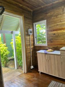 马太Camp Taveuni的一间设有木墙的客房和一间带窗户的厨房