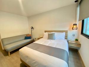墨西哥城Darwin 8的一间卧室配有一张大床和一张沙发