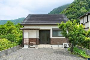 舞鹤市Seaside Villa Nagi的一座带车库的小房子和一座山
