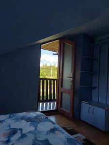 BăniţaCabană cu teren de tenis的一间卧室设有一张床,并有通往阳台的门