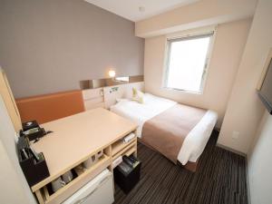 东京Super Hotel Premier Akasaka的小房间设有一张床和一张书桌