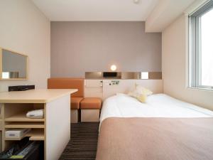 东京Super Hotel Premier Akasaka的配有一张床和一张书桌的酒店客房