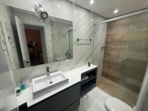 圣若泽杜斯坎普斯Flat Premium -Acesso a pé ao shopping Center vale - Edifício Summit (Ar condicionado)的白色的浴室设有水槽和淋浴。