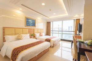 广州广州市骏田国际酒店公馆的酒店客房配有两张床和一张书桌