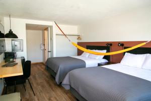 南福克LOGE Wolf Creek的酒店客房的上面设有两张带黄绳的床铺。
