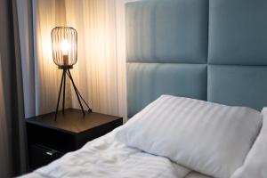 格但斯克Moon Apartments Gdańsk的一间卧室,配有一张床和床头灯