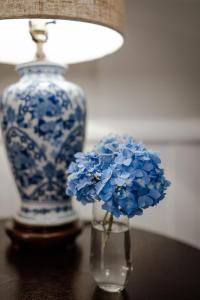 克莱顿Beechwood Inn的花瓶,花朵蓝色,桌子上有一盏灯