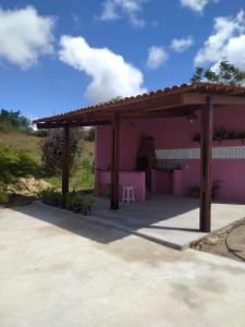 Serra de São BentoChalés Rosados的粉红色的房屋,设有木制凉亭