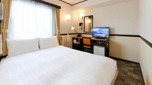 大阪Toyoko Inn Osaka Abeno Tennoji的酒店客房配有一张床、一张书桌和一台电视。
