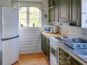 HusumHoliday home Husum的厨房配有绿色橱柜和白色冰箱