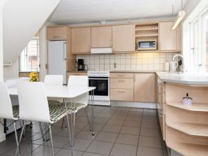 霍耶Holiday home Højer III的厨房配有桌子和白色椅子
