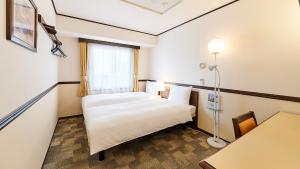 大阪Toyoko Inn Osaka Abeno Tennoji的酒店客房设有床和窗户。