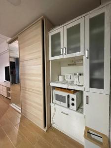 清迈Kiang Mo Gumpuju的厨房配有白色橱柜和微波炉
